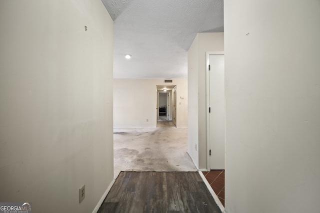 hallway featuring hardwood / wood-style floors and a textured ceiling