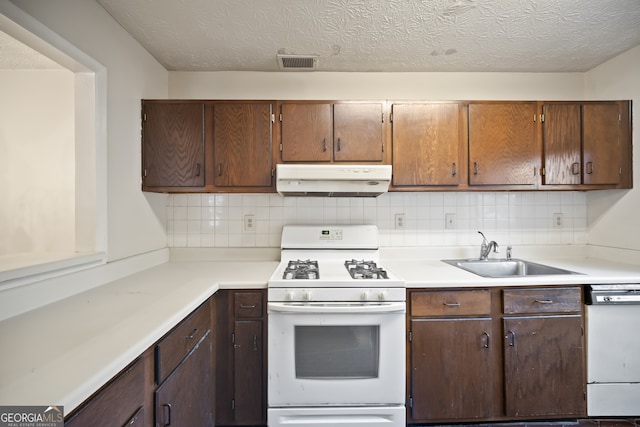 kitchen featuring tasteful backsplash, sink, a textured ceiling, and white appliances