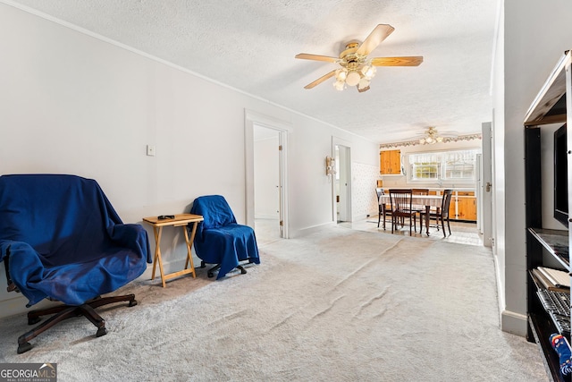 sitting room with ceiling fan, light colored carpet, a textured ceiling, and ornamental molding