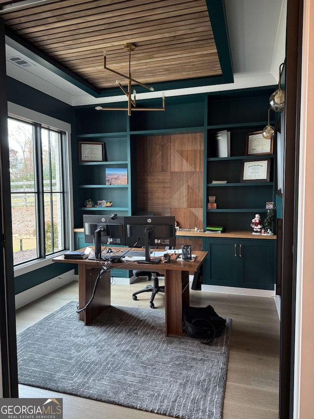 home office with hardwood / wood-style floors, built in desk, wood ceiling, and a chandelier