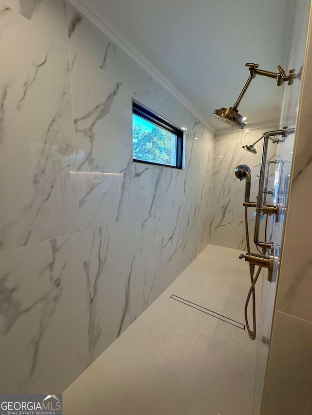 bathroom featuring a tile shower and ornamental molding