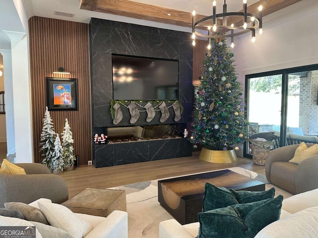 living area featuring wood finished floors, an inviting chandelier, and visible vents
