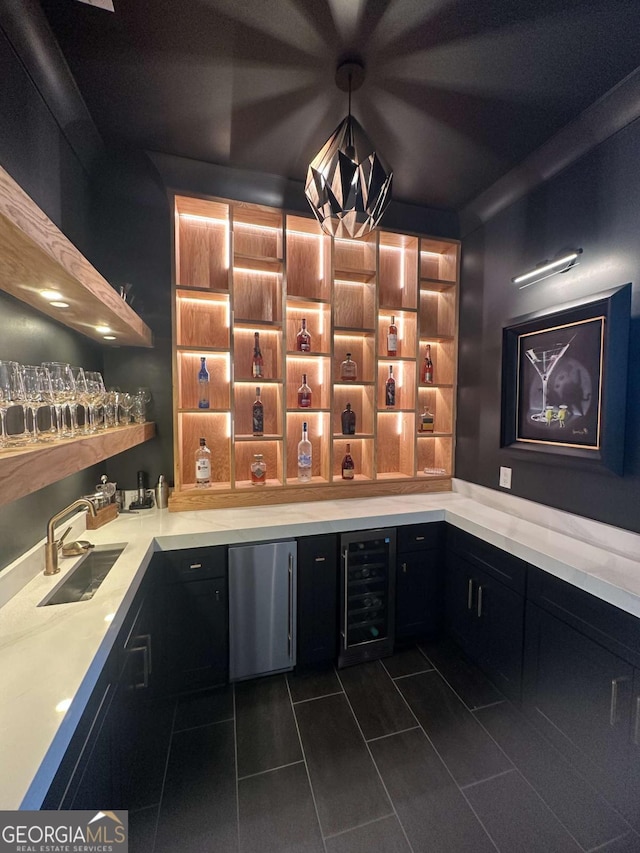 bar featuring indoor wet bar, refrigerator, beverage cooler, a sink, and dark tile patterned flooring