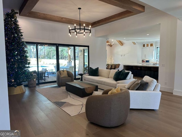 living room featuring hardwood / wood-style flooring, sink, and an inviting chandelier