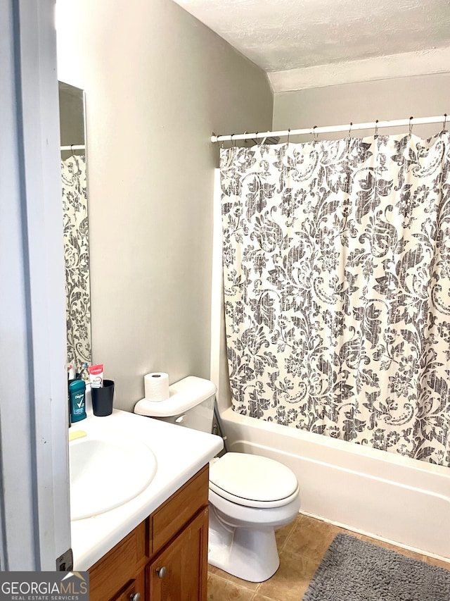 bathroom with tile patterned flooring, vanity, a textured ceiling, and toilet