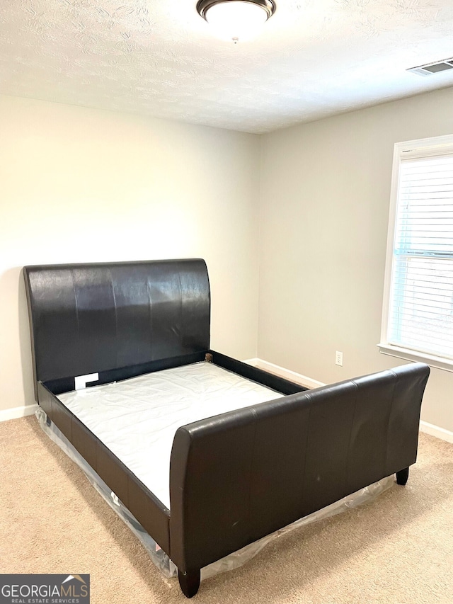 carpeted bedroom with a textured ceiling