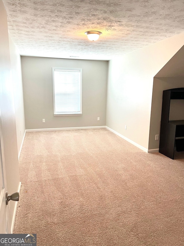 carpeted spare room with a textured ceiling