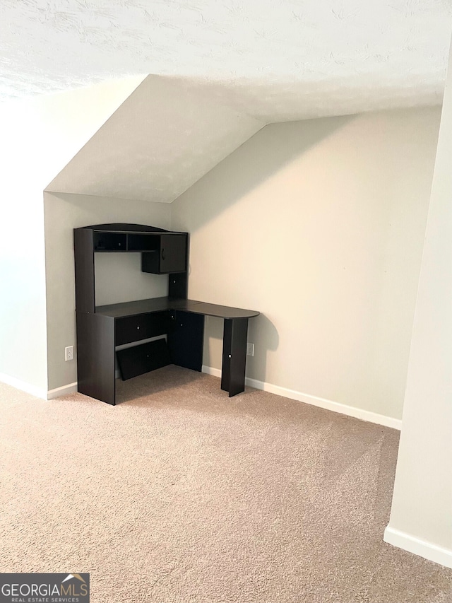 unfurnished living room featuring carpet, a textured ceiling, and vaulted ceiling