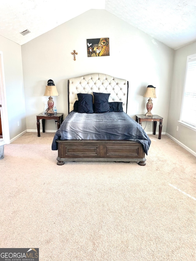 bedroom with light colored carpet and lofted ceiling