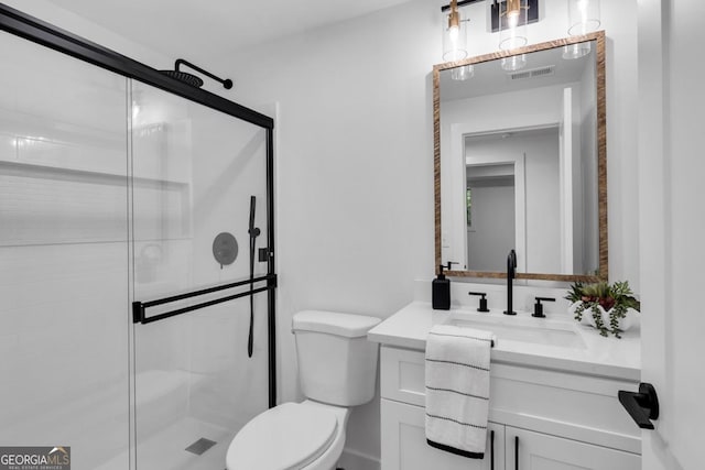 bathroom featuring vanity, toilet, and a shower with shower door