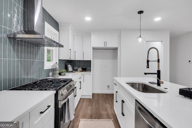 kitchen featuring white cabinets, sink, wall chimney range hood, and stainless steel appliances