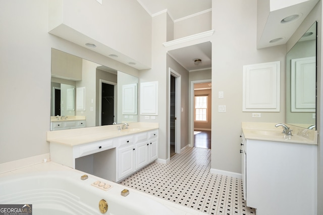 bathroom with a tub, vanity, and ornamental molding