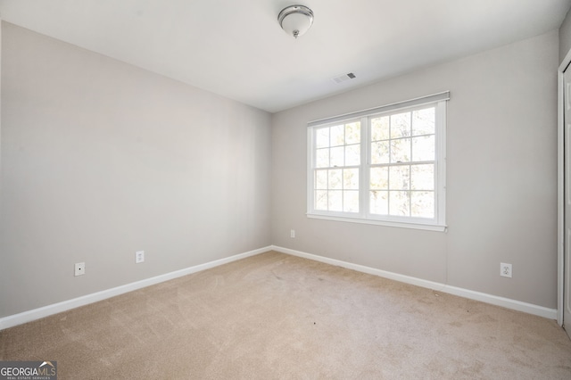 unfurnished room featuring light colored carpet