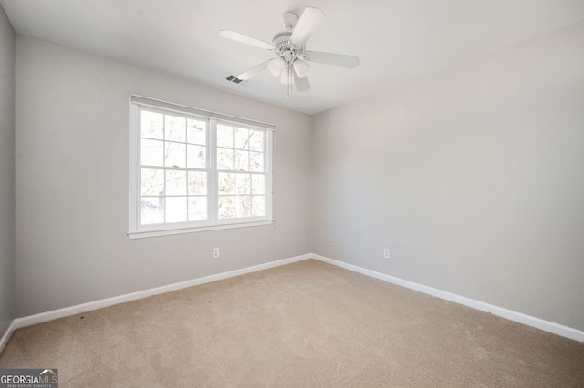 spare room featuring light colored carpet and ceiling fan