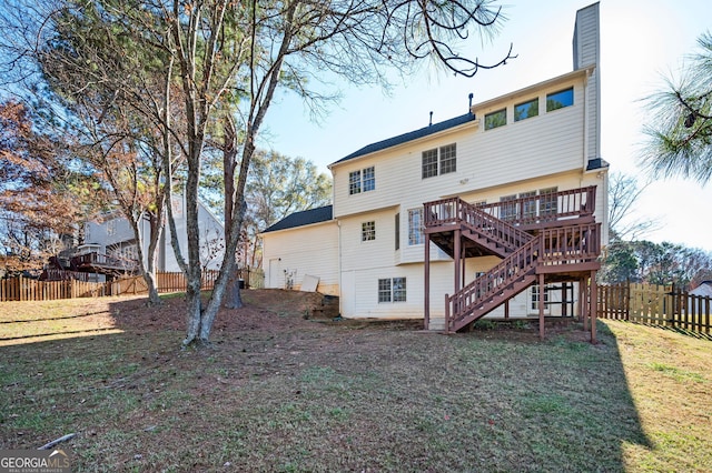 rear view of property featuring a wooden deck and a yard