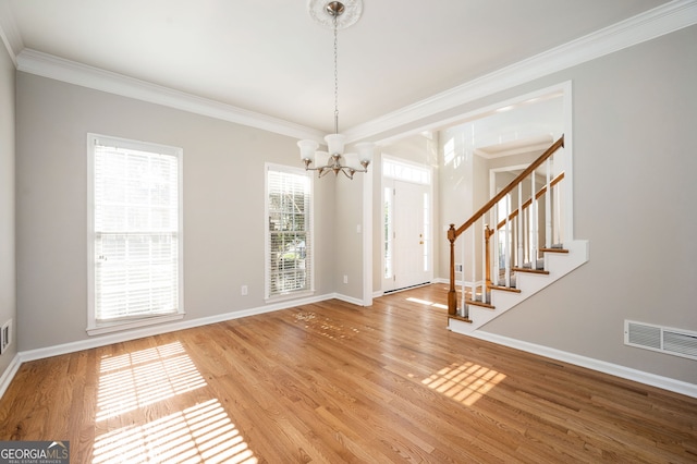 interior space with wood-type flooring, an inviting chandelier, and crown molding