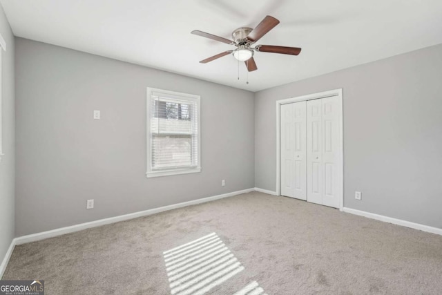 unfurnished bedroom with a ceiling fan, carpet, baseboards, and a closet