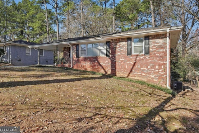 ranch-style home featuring central AC unit, brick siding, and a porch