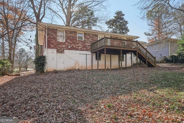 back of property with brick siding, fence, a wooden deck, and stairs