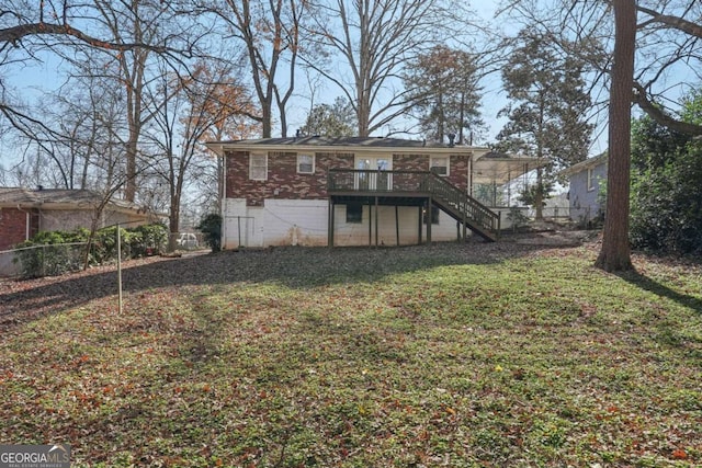 back of house with brick siding, a yard, stairway, fence, and a deck