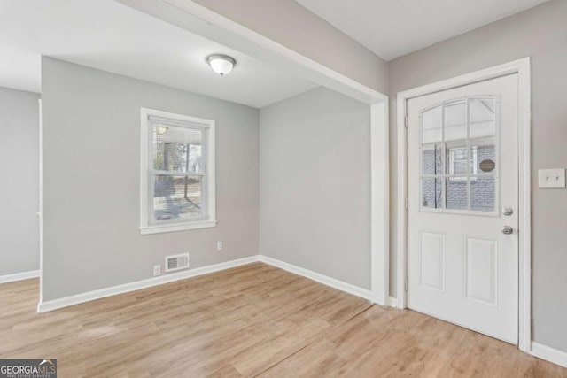 foyer featuring light wood-style floors, baseboards, and visible vents