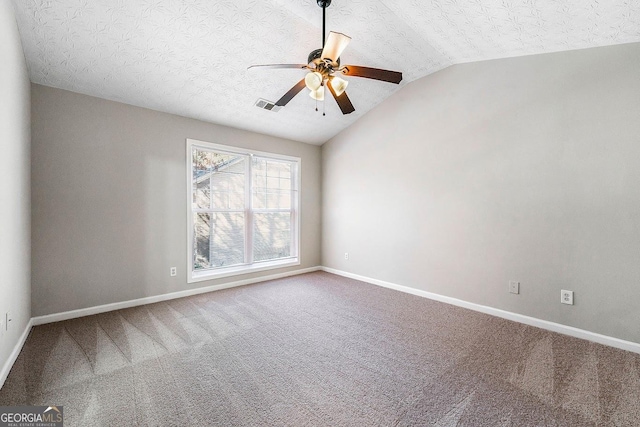 empty room with a textured ceiling, ceiling fan, carpet floors, and vaulted ceiling