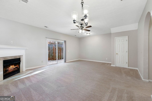 unfurnished living room featuring light carpet, a textured ceiling, and ceiling fan with notable chandelier