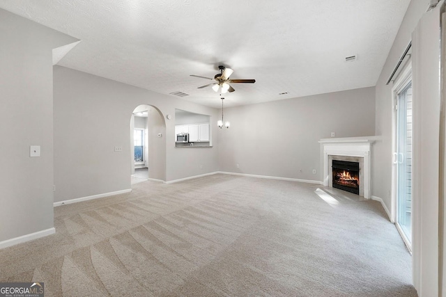 unfurnished living room with ceiling fan, light colored carpet, and a textured ceiling