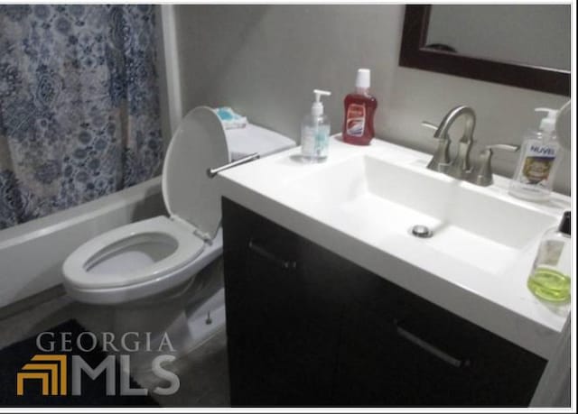 full bathroom featuring shower / bath combo with shower curtain, vanity, and toilet