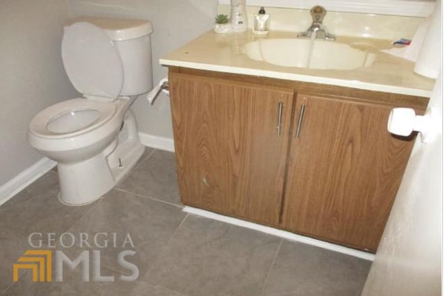 bathroom featuring tile patterned flooring, vanity, and toilet