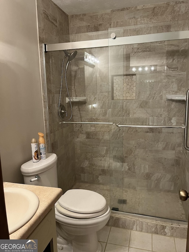 bathroom featuring toilet, a stall shower, and vanity