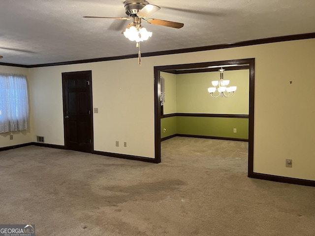 empty room featuring baseboards, carpet, ceiling fan with notable chandelier, and crown molding