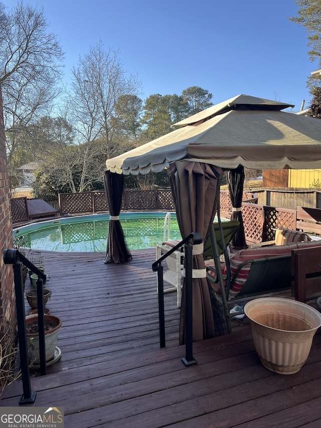 wooden deck featuring fence and a fenced in pool