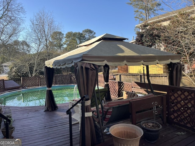 wooden terrace with a fenced in pool, a gazebo, and fence