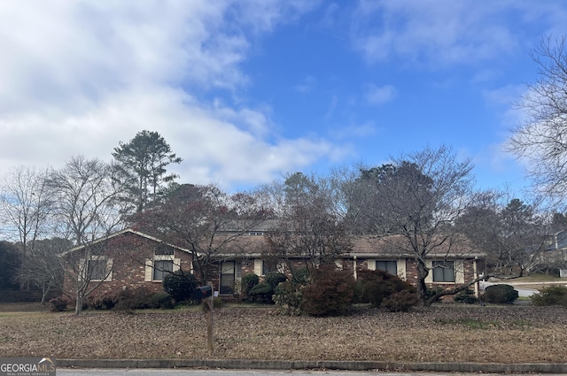 single story home featuring brick siding