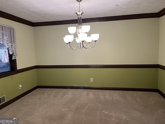 carpeted empty room featuring a chandelier, visible vents, ornamental molding, and baseboards