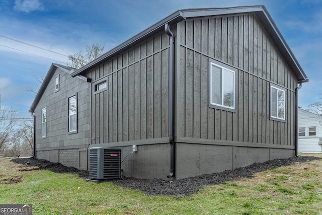 view of side of property featuring central AC and a lawn