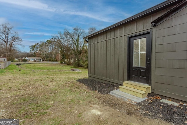 view of exterior entry with a lawn