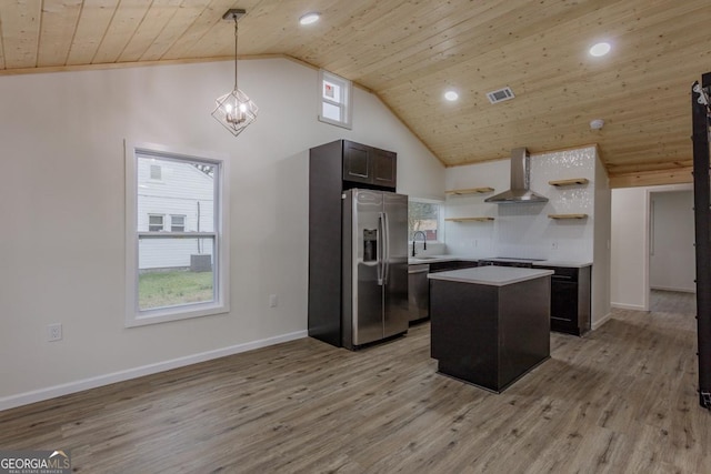 kitchen with sink, light hardwood / wood-style flooring, wall chimney exhaust hood, appliances with stainless steel finishes, and a kitchen island