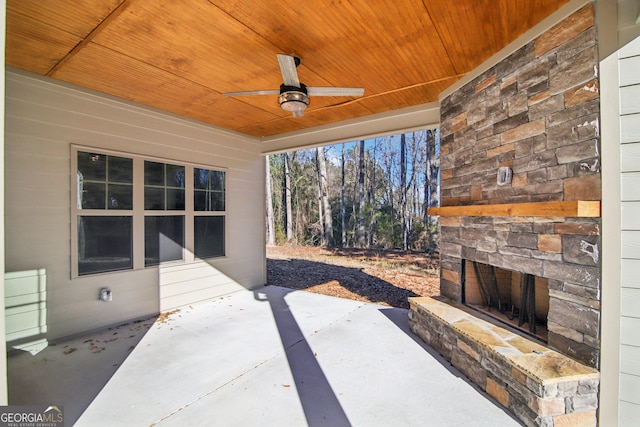 view of patio with ceiling fan and an outdoor stone fireplace