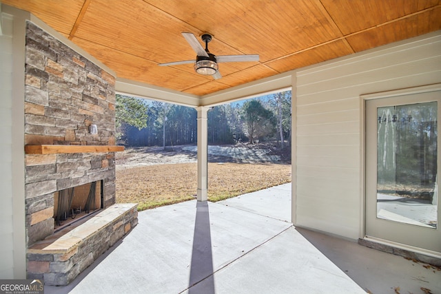 view of patio with an outdoor stone fireplace and ceiling fan