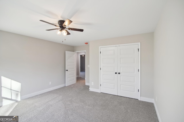 unfurnished bedroom with carpet flooring, ceiling fan, and a closet