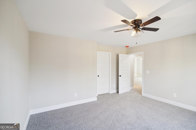 carpeted spare room featuring ceiling fan