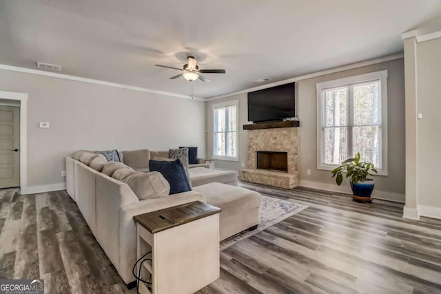 living room featuring plenty of natural light, dark hardwood / wood-style floors, and ornamental molding