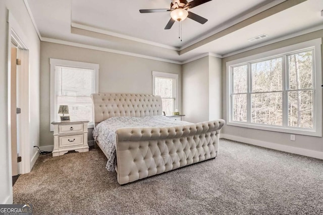 bedroom with a raised ceiling, ceiling fan, carpet floors, and ornamental molding