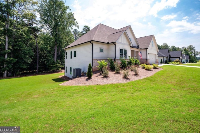 view of side of property featuring a lawn, cooling unit, and a garage