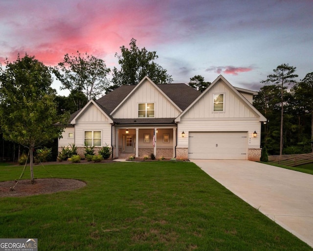 view of front of home featuring a porch, a yard, and a garage