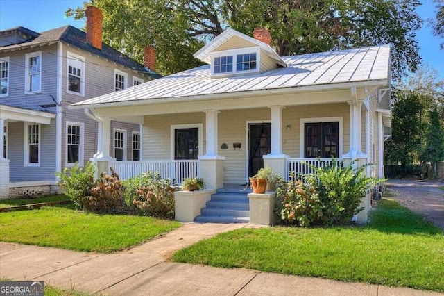 view of front of home with a front yard and covered porch