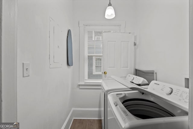 laundry room with wood-type flooring, electric panel, and independent washer and dryer