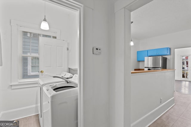 laundry room with separate washer and dryer and light hardwood / wood-style flooring